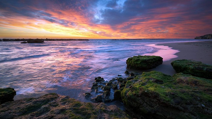 Rocky beach at sunset with colorful sky
