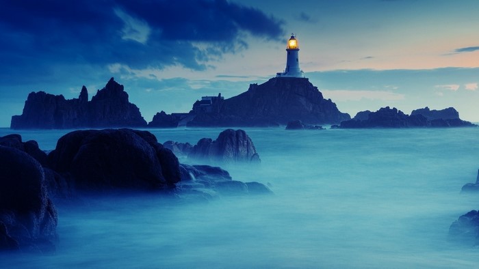 Lighthouse on a rocky island at dusk