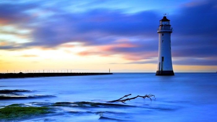 Lighthouse on the water at sunset