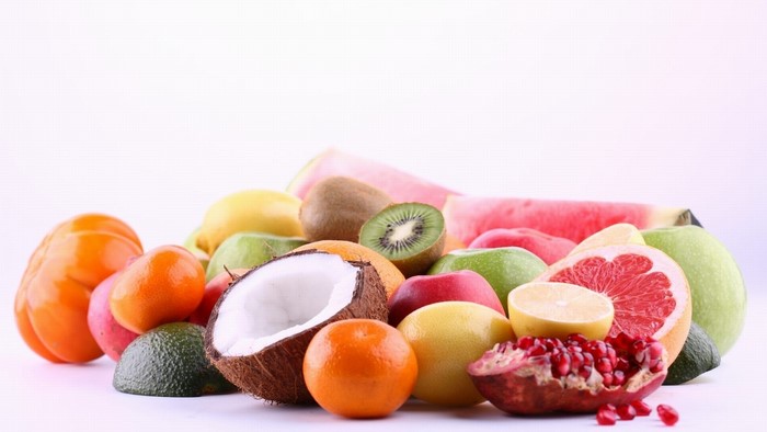 Assortment of tropical fruits including coconut, kiwi, and grapefruit