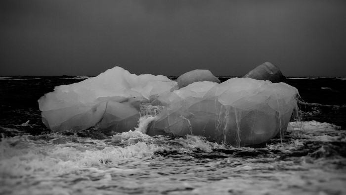 Icebergs floating in choppy water under a dark sky