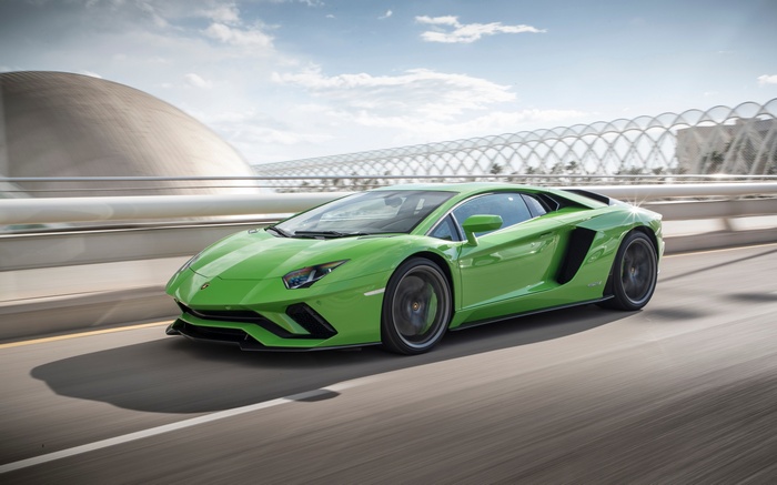 Green Lamborghini Aventador S driving on a road