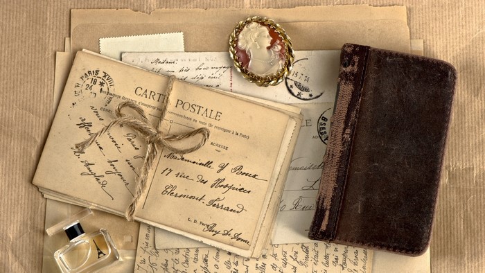 Vintage postcards, cameo brooch, and leather-bound book