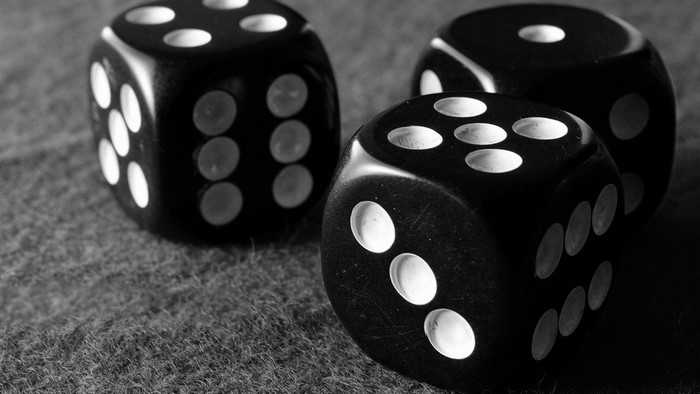 Three black dice on a textured surface