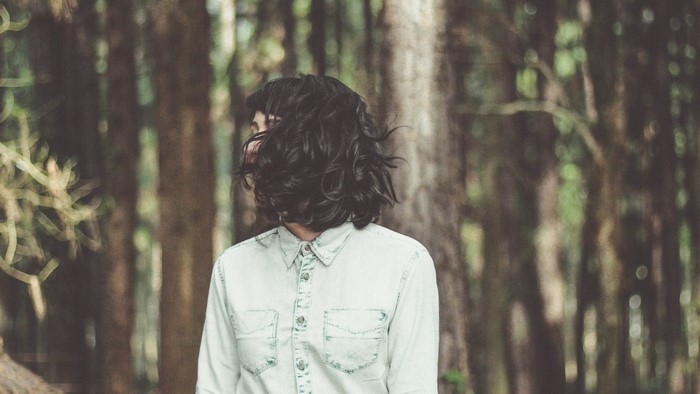 Person in a denim shirt in a forest