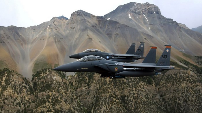 US Air Force F-15 Eagles fly over mountains