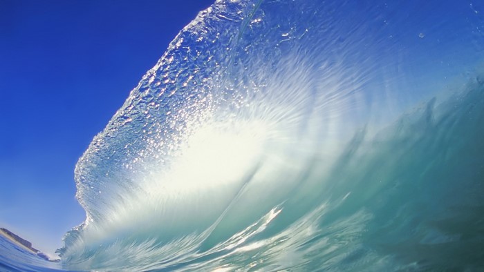 Ocean Wave Crashing Under Blue Sky