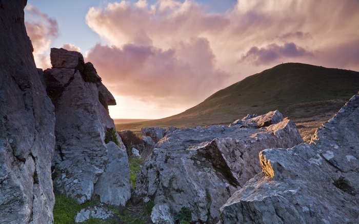 Rocky landscape with rolling hills and cloudy sky
