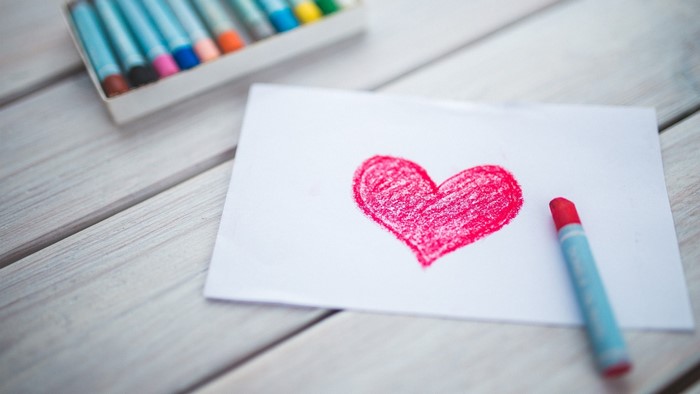 Red heart drawing with crayons on paper