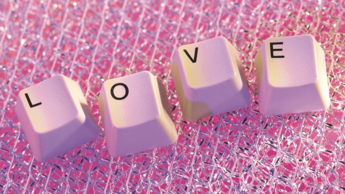 Keyboard keys spelling LOVE on a pink background