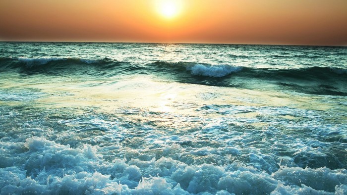 Sunset over the sea with waves