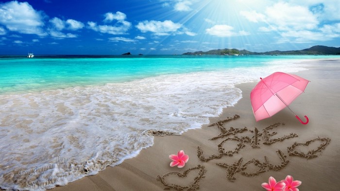Beach with "I Love You" written in sand and pink umbrella