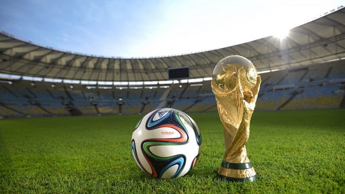 World Cup Trophy and Football on Stadium Field