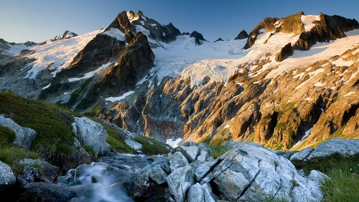 Snow-capped mountains with a glacier and stream