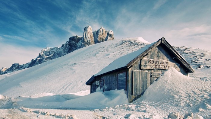 Wooden cabin in snowy Dolomites mountains