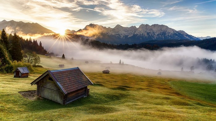 Mountain valley landscape with sunrise and fog