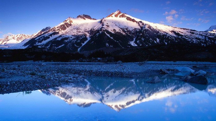 Snow-capped mountains reflected in a calm lake