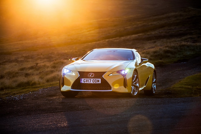 Yellow 2018 Lexus LC 500 on a dirt road at sunset