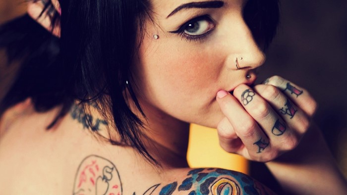 Tattooed woman with piercings and makeup