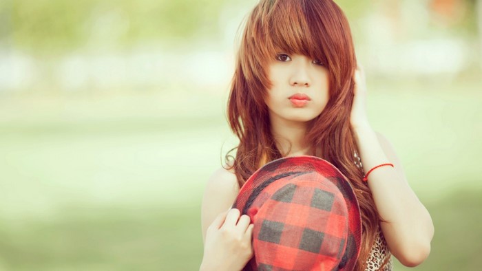 Cute girl holding a hat