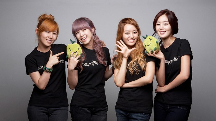 Four Korean girls in black t-shirts holding plush toys