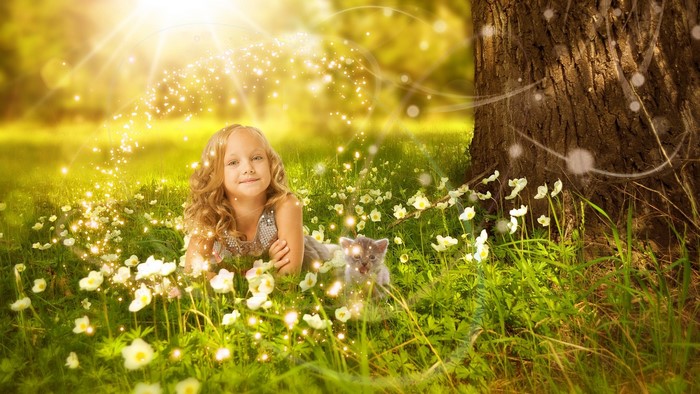 Girl and kitten in a magical meadow