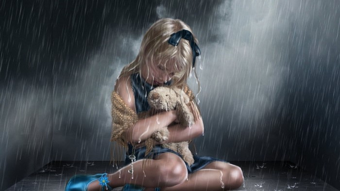 Little girl hugging teddy bear in the rain