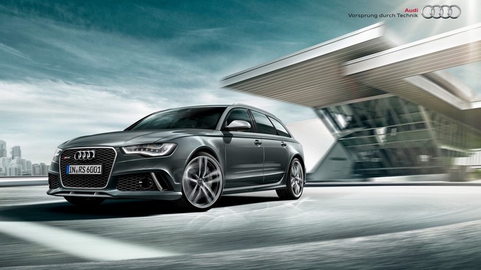 Audi RS6 Avant driving past modern architecture