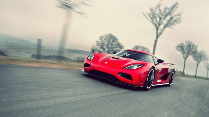 Red Koenigsegg Agera driving on a road