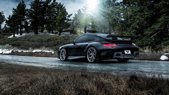 Black Porsche 911 Carrera on a Forest Road