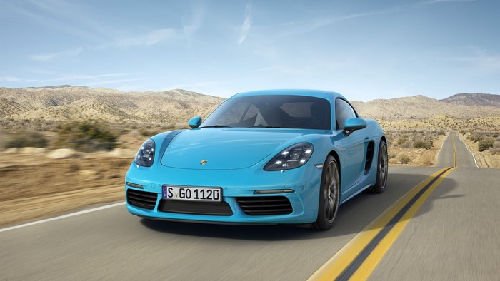 Blue Porsche 718 Cayman driving on a desert road