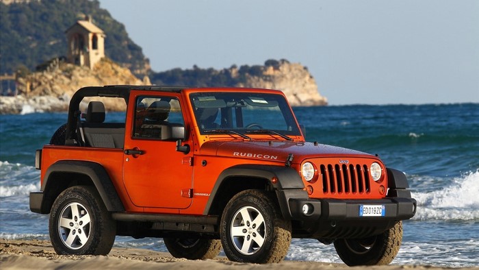 Orange Jeep Wrangler Rubicon on a Beach