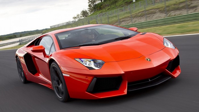 Orange Lamborghini Aventador driving on a track