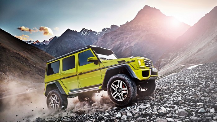 Yellow Mercedes-Benz G500 4x4 driving on rocky mountain road