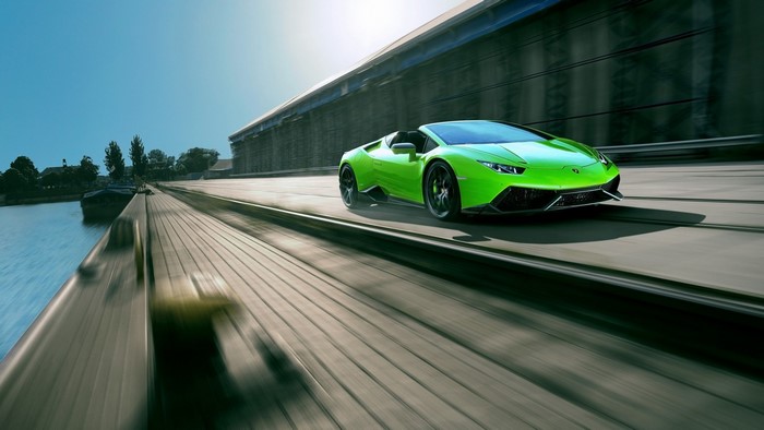 Green Lamborghini Huracan Spyder driving on a road