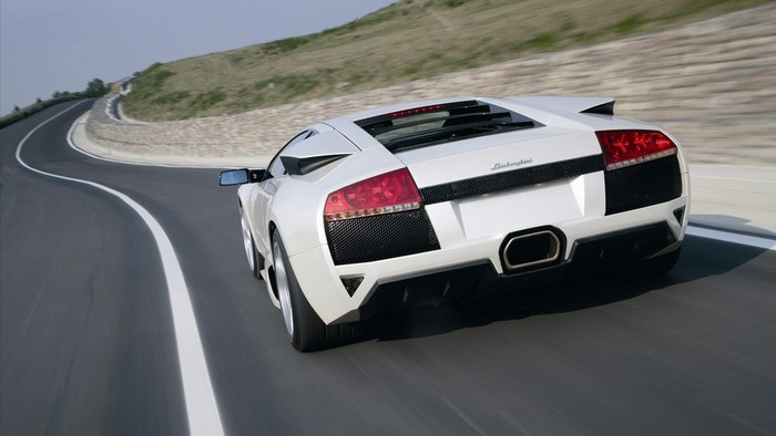 White Lamborghini Murcielago LP640 driving on a winding road