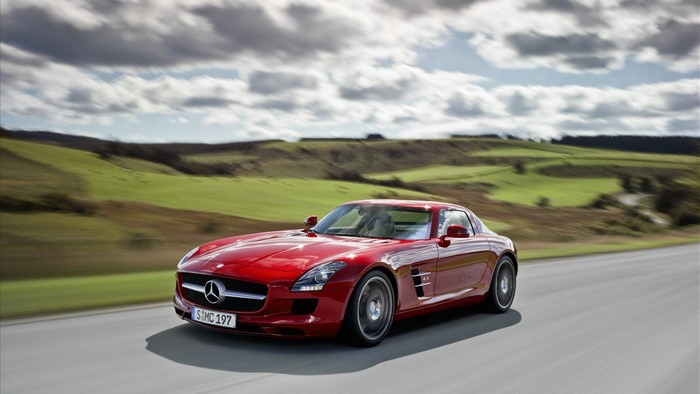 Red Mercedes-Benz SLS AMG driving on a road