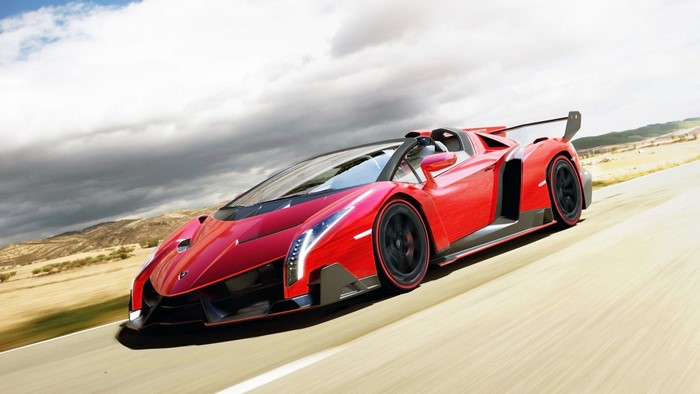 Red 2014 Lamborghini Veneno Roadster driving on a road
