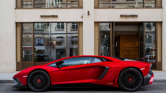 Red Lamborghini Aventador parked in front of Dsquared2 store