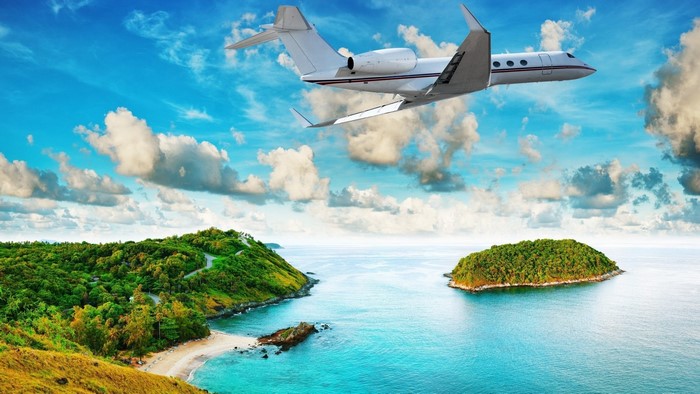 Airplane flying over tropical islands and ocean