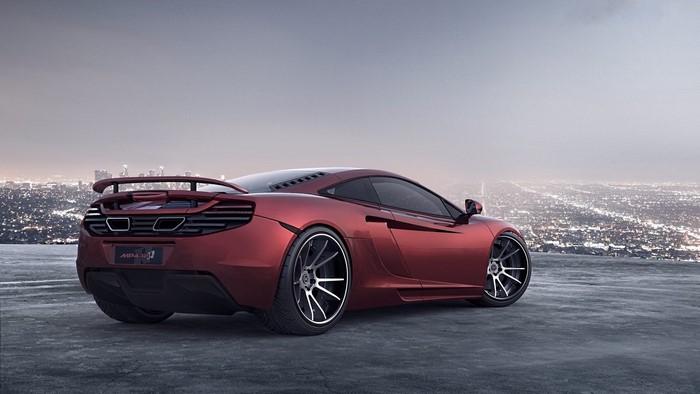 Red McLaren 12C sports car on a rooftop overlooking a city