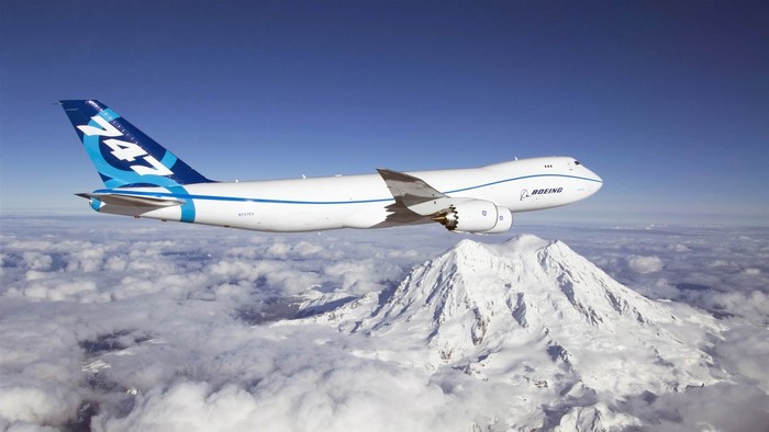 Boeing 747 cargo plane flying over a snowy mountain