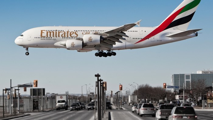 Emirates Airplane landing over a street