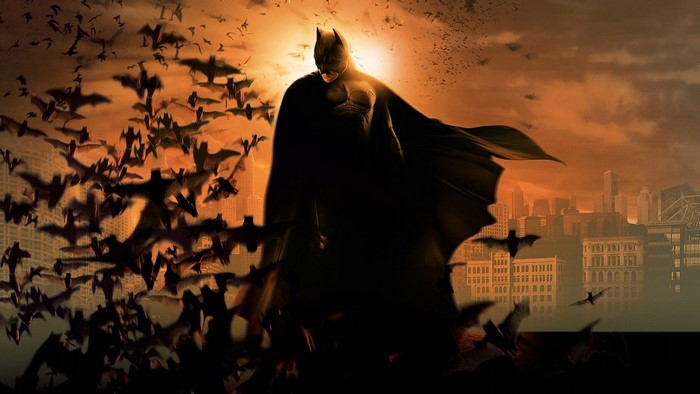 Batman surrounded by bats over a city skyline