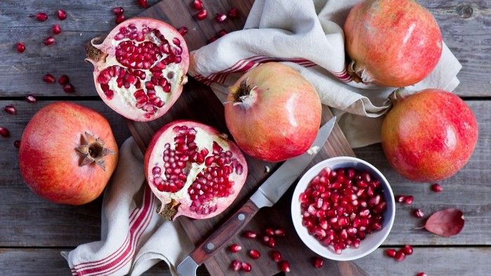 Pomegranates and Seeds on Wooden Table