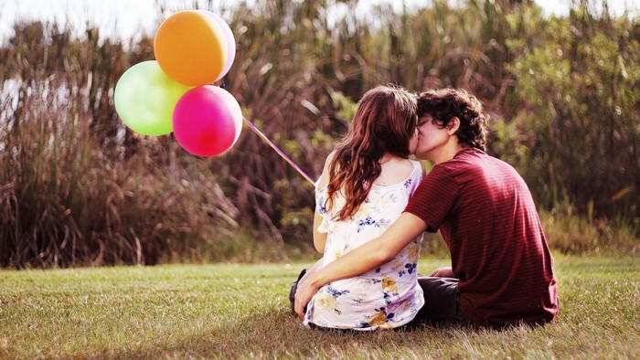 Couple kissing with balloons