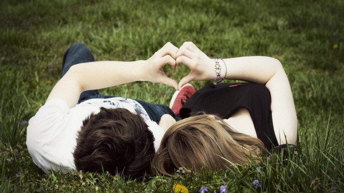 Romantic couple making heart shape with hands