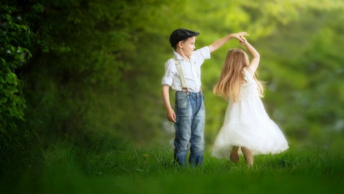 Boy and Girl Dancing in a Grassy Field