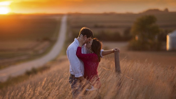 Couple kissing at sunset in a field