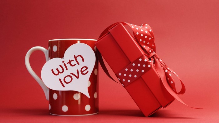 Red mug with white polka dots and a red gift box
